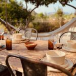 Breakfast table on the terrace at Finca W with a hammock and the pool beyond